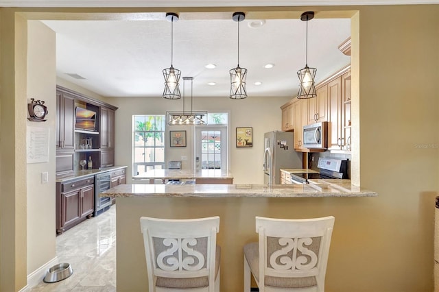 5518 Luminar Pointe Ln, Apollo Beach, FL 33572 - kitchen featuring stainless steel appliances, beverage cooler, a peninsula, light stone counters, and a breakfast bar