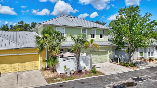 5518 Luminar Pointe Ln, Apollo Beach, FL 33572 - view of front of property featuring a metal roof, concrete driveway, stucco siding, a standing seam roof, and a garage