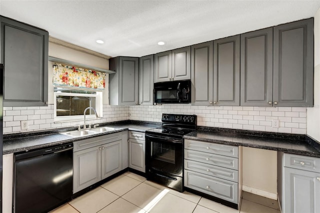915 S Miller Rd, Valrico, FL 33594 - kitchen with black appliances, gray cabinetry, dark countertops, light tile patterned floors, and backsplash