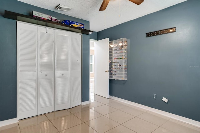 915 S Miller Rd, Valrico, FL 33594 - unfurnished bedroom featuring a closet, tile patterned floors, a textured ceiling, and ceiling fan