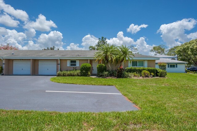 1510 Palmer Ct, Palm Harbor, FL 34685 - ranch-style house with a garage, stucco siding, asphalt driveway, and a front lawn