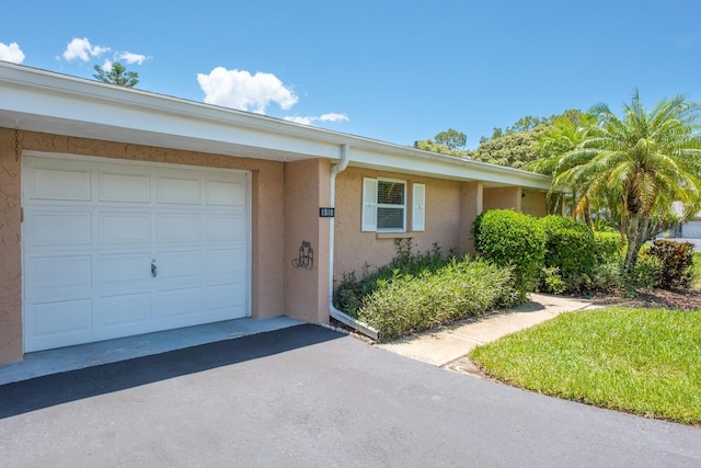 1510 Palmer Ct, Palm Harbor, FL 34685 - view of exterior entry with stucco siding, driveway, and an attached garage