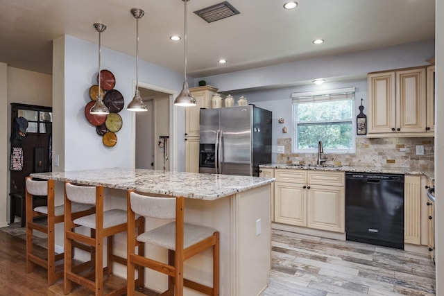 1510 Palmer Ct, Palm Harbor, FL 34685 - kitchen with dishwasher, stainless steel fridge, a kitchen breakfast bar, light stone counters, and light wood finished floors