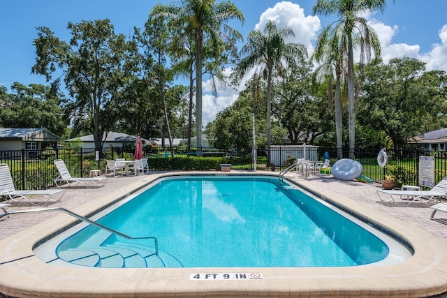 1510 Palmer Ct, Palm Harbor, FL 34685 - community pool with a patio area and view of wooded area