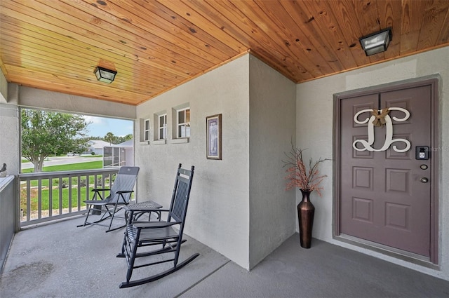 2306 Emerald Lake Dr, Sun City Center, FL 33573 - view of exterior entry featuring stucco siding and covered porch