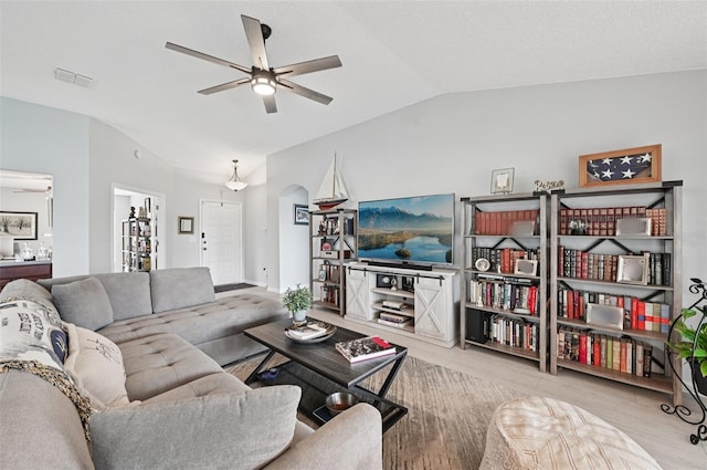 2306 Emerald Lake Dr, Sun City Center, FL 33573 - living room with ceiling fan, lofted ceiling, arched walkways, and wood finished floors