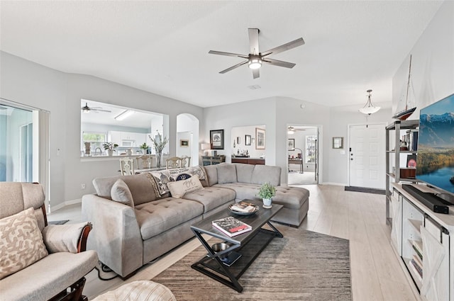 2306 Emerald Lake Dr, Sun City Center, FL 33573 - living room featuring ceiling fan, light wood-style flooring, and arched walkways