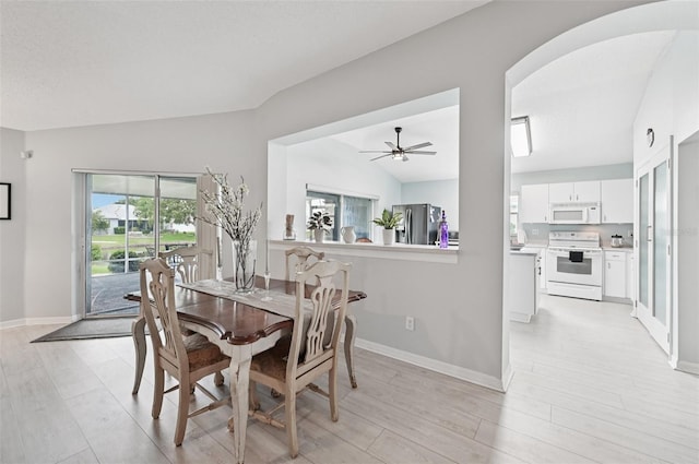 2306 Emerald Lake Dr, Sun City Center, FL 33573 - dining area featuring light wood-type flooring, arched walkways, lofted ceiling, and a ceiling fan