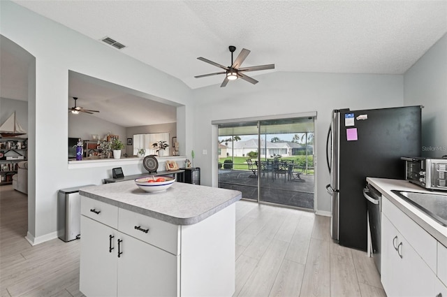 2306 Emerald Lake Dr, Sun City Center, FL 33573 - kitchen featuring lofted ceiling, a ceiling fan, light wood finished floors, light countertops, and white cabinetry