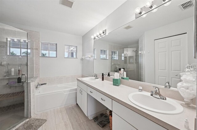 2306 Emerald Lake Dr, Sun City Center, FL 33573 - bathroom featuring a stall shower, double vanity, and a bath