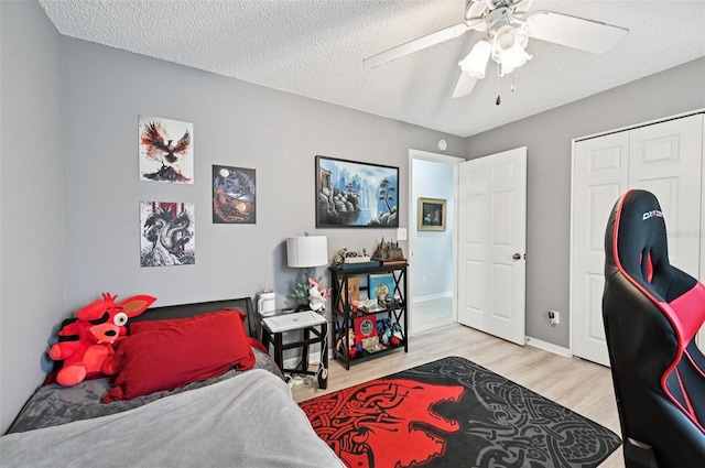 2306 Emerald Lake Dr, Sun City Center, FL 33573 - bedroom with wood finished floors, a textured ceiling, a ceiling fan, and a closet