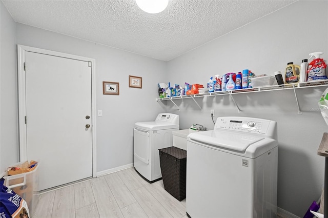 2306 Emerald Lake Dr, Sun City Center, FL 33573 - laundry room with washing machine and clothes dryer, a textured ceiling, and light wood-type flooring