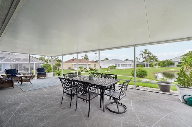 2306 Emerald Lake Dr, Sun City Center, FL 33573 - sunroom featuring outdoor dining space, a residential view, and a water view