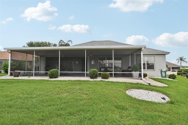 2306 Emerald Lake Dr, Sun City Center, FL 33573 - back of property featuring a sunroom, a lawn, and stucco siding