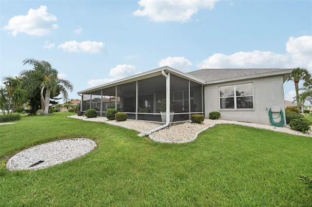 2306 Emerald Lake Dr, Sun City Center, FL 33573 - back of house featuring a sunroom, a yard, and stucco siding