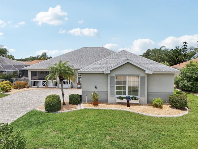 2306 Emerald Lake Dr, Sun City Center, FL 33573 - ranch-style home featuring a front yard, a shingled roof, and stucco siding