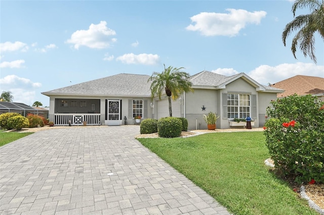 2306 Emerald Lake Dr, Sun City Center, FL 33573 - single story home featuring decorative driveway, stucco siding, a front yard, covered porch, and a garage