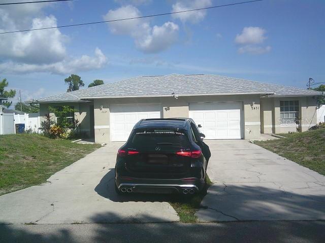 2429/2431 Quentin Ave S, Lehigh Acres, FL 33973 - view of front of home with stucco siding, driveway, and an attached garage