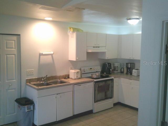 2429/2431 Quentin Ave S, Lehigh Acres, FL 33973 - kitchen with white appliances, under cabinet range hood, white cabinetry, and light countertops