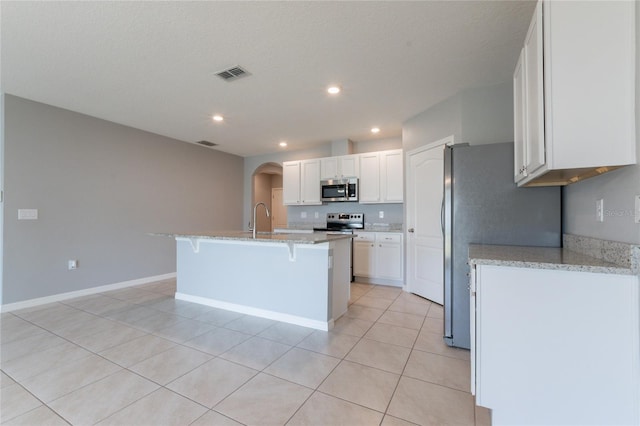 3079 Bethpage Loop, Mount Dora, FL 32757 - kitchen with stainless steel microwave, arched walkways, electric range, a breakfast bar area, and white cabinets