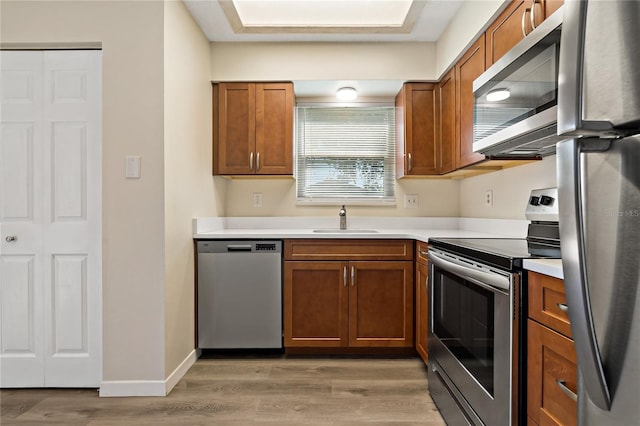2901 Bay View Dr, Safety Harbor, FL 34695 - kitchen with appliances with stainless steel finishes, light wood-type flooring, and brown cabinetry