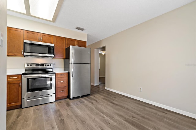 2901 Bay View Dr, Safety Harbor, FL 34695 - kitchen featuring appliances with stainless steel finishes, brown cabinets, and light countertops