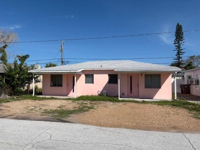150 147th Ave E, Madeira Beach, FL 33708 - view of front of home with stucco siding and dirt driveway