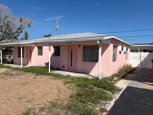 150 147th Ave E, Madeira Beach, FL 33708 - back of house featuring stucco siding and a gate