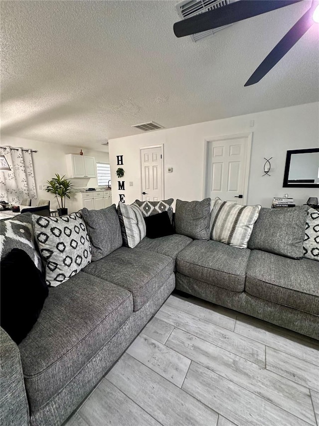 13186 Thrush St, Spring Hill, FL 34609 - living area featuring a ceiling fan, a textured ceiling, and light wood-type flooring