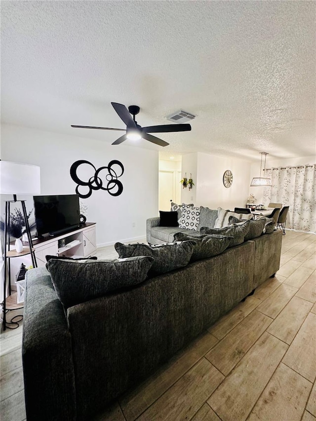 13186 Thrush St, Spring Hill, FL 34609 - living area featuring light wood-style floors, ceiling fan, and a textured ceiling