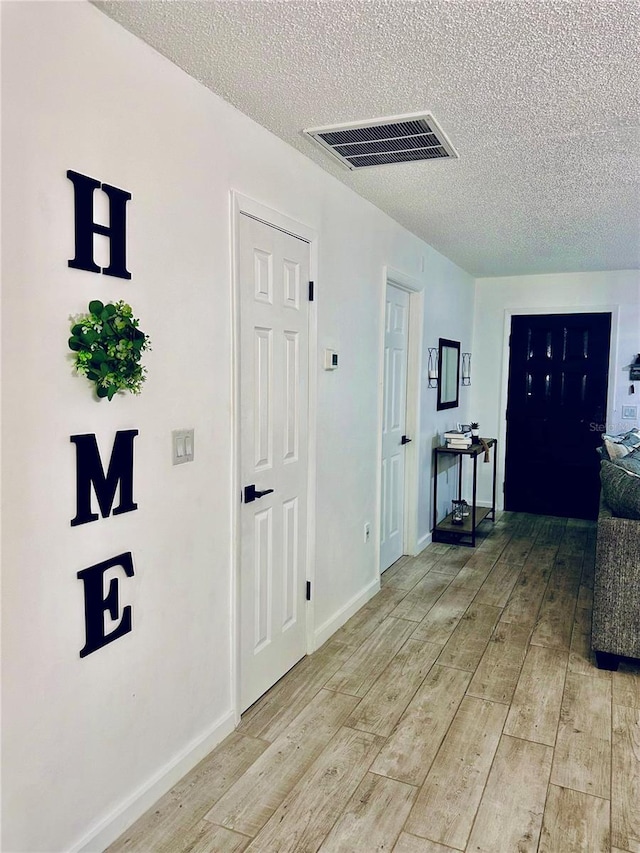 13186 Thrush St, Spring Hill, FL 34609 - corridor featuring light wood-style floors and a textured ceiling