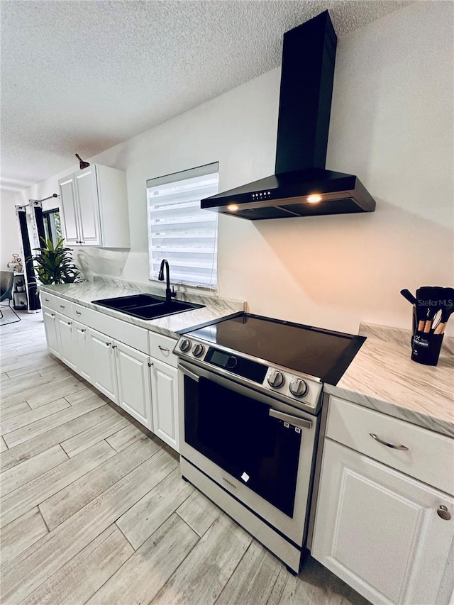 13186 Thrush St, Spring Hill, FL 34609 - kitchen with electric range, wall chimney exhaust hood, light wood finished floors, a textured ceiling, and light countertops