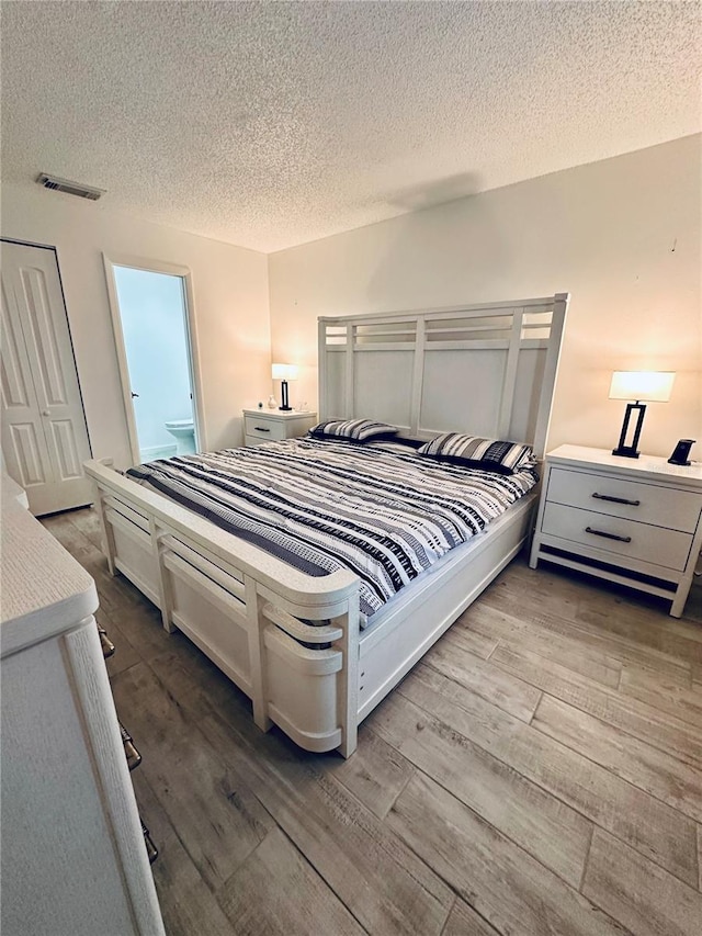 13186 Thrush St, Spring Hill, FL 34609 - bedroom featuring wood finished floors and a textured ceiling
