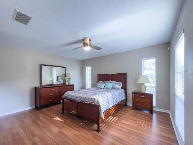 4404 Hickory Branch Ct, Brandon, FL 33511 - bedroom with wood finished floors, multiple windows, a ceiling fan, and a textured ceiling