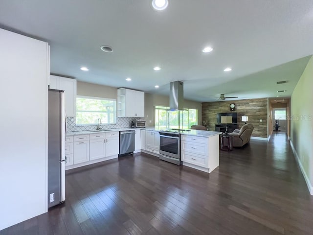 4404 Hickory Branch Ct, Brandon, FL 33511 - kitchen featuring stainless steel appliances, island range hood, a peninsula, open floor plan, and white cabinetry