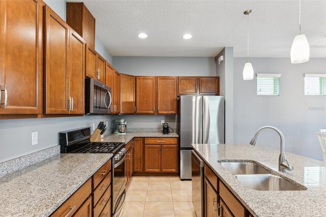 5831 Caldera Ridge Dr, Lithia, FL 33547 - kitchen with appliances with stainless steel finishes, brown cabinets, decorative light fixtures, light stone counters, and a textured ceiling
