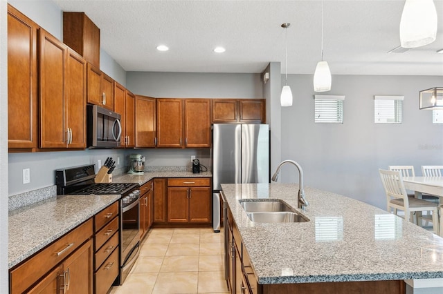5831 Caldera Ridge Dr, Lithia, FL 33547 - kitchen featuring appliances with stainless steel finishes, a kitchen island with sink, light stone counters, decorative light fixtures, and recessed lighting