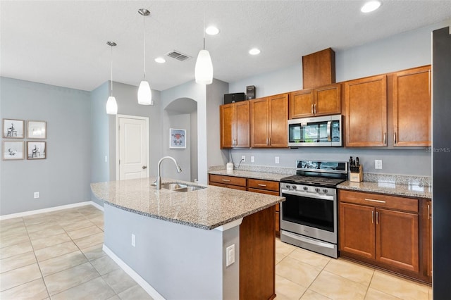 5831 Caldera Ridge Dr, Lithia, FL 33547 - kitchen with appliances with stainless steel finishes, light tile patterned floors, brown cabinetry, light stone countertops, and recessed lighting