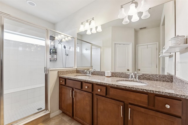 5831 Caldera Ridge Dr, Lithia, FL 33547 - bathroom with a shower stall, double vanity, tile patterned flooring, and a chandelier