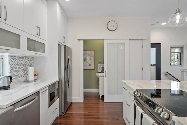 325 5th Ave S Unit 9, Saint Petersburg, FL 33701 - kitchen featuring stainless steel appliances, decorative backsplash, dark wood-style floors, decorative light fixtures, and white cabinetry