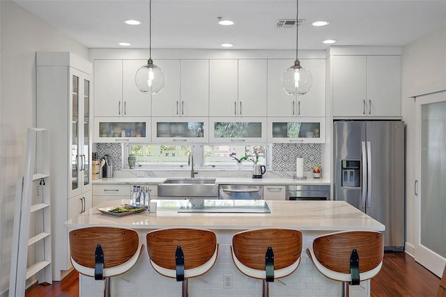 325 5th Ave S Unit 9, Saint Petersburg, FL 33701 - kitchen with stainless steel appliances, a kitchen breakfast bar, dark wood finished floors, backsplash, and recessed lighting
