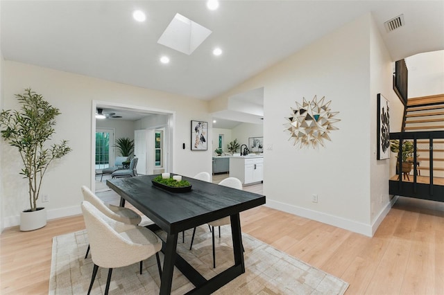 2272 Adam Ct, Palm Harbor, FL 34683 - dining room featuring light wood-style floors, vaulted ceiling, a skylight, recessed lighting, and stairs