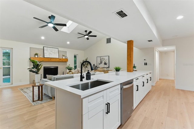 2272 Adam Ct, Palm Harbor, FL 34683 - kitchen with stainless steel dishwasher, a ceiling fan, light wood-style flooring, white cabinets, and recessed lighting