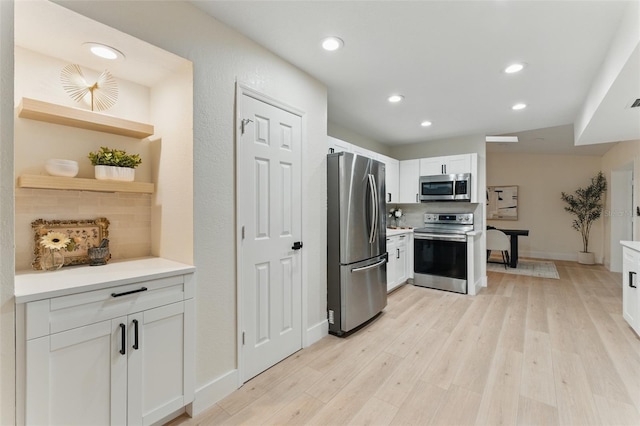 2272 Adam Ct, Palm Harbor, FL 34683 - kitchen featuring appliances with stainless steel finishes, recessed lighting, backsplash, white cabinets, and light wood finished floors