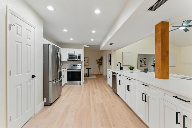 2272 Adam Ct, Palm Harbor, FL 34683 - kitchen featuring stainless steel appliances, recessed lighting, white cabinetry, light countertops, and light wood-style floors