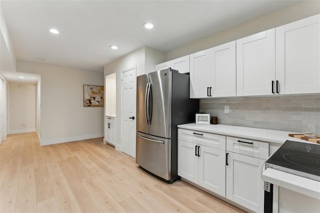 2272 Adam Ct, Palm Harbor, FL 34683 - kitchen featuring freestanding refrigerator, decorative backsplash, light countertops, white cabinetry, and recessed lighting