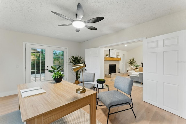 2272 Adam Ct, Palm Harbor, FL 34683 - office with a ceiling fan, french doors, light wood finished floors, a fireplace, and a textured ceiling