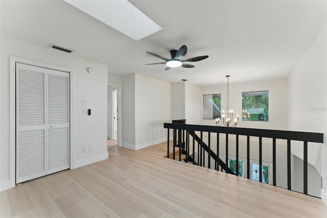 2272 Adam Ct, Palm Harbor, FL 34683 - corridor featuring a chandelier, an upstairs landing, a skylight, and wood finished floors
