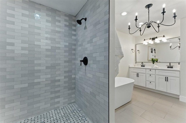2272 Adam Ct, Palm Harbor, FL 34683 - bathroom with tiled shower, a chandelier, double vanity, a freestanding bath, and tile patterned flooring