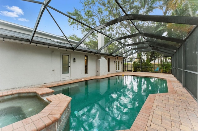 2272 Adam Ct, Palm Harbor, FL 34683 - view of swimming pool featuring glass enclosure, a patio, and a pool with connected hot tub